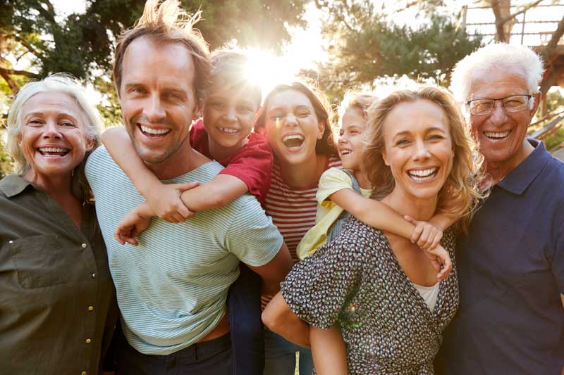 multi generation family smiling and looking towards viewer